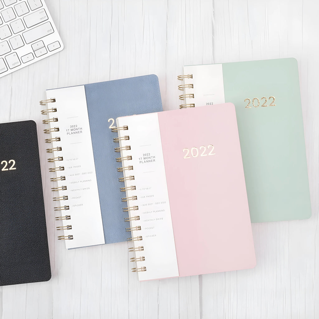 Blue 17-month 2022-2023 student planner with coil binding, month grid, and pockets.