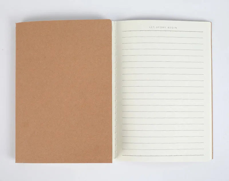 Softcover thread-bound notebook open on a table, showing flat-lay binding and lined paper.