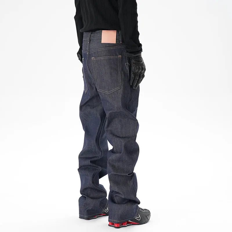 Man's dark blue loose-fit straight leg denim jeans on a neutral background.