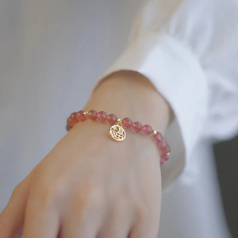 A New Chinese style glass bracelet with strawberry quartz stones and a blessing card.