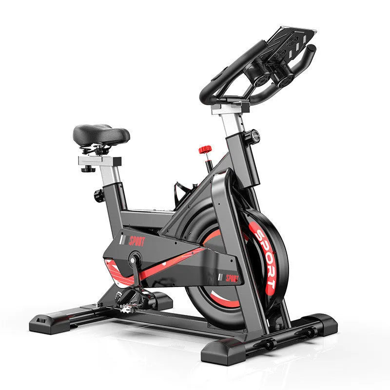 Black upright spinning bike with console and infinite resistance knob on a home gym floor
