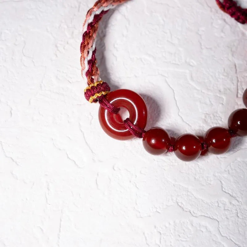 Red agate carrying strap bracelet with elk element on neutral background