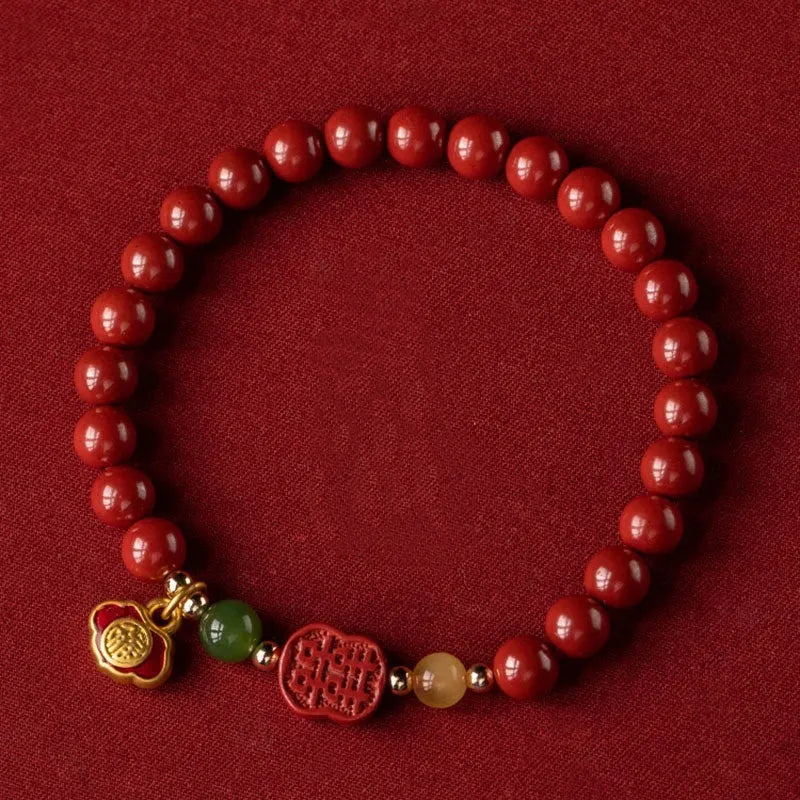 Emperor sandstone bracelet with fu charm on wrist, showing cinnabar and stone beads.