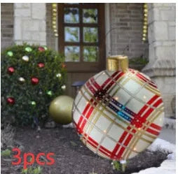 Large red and white striped inflatable Christmas ball ornament hanging on an outdoor tree