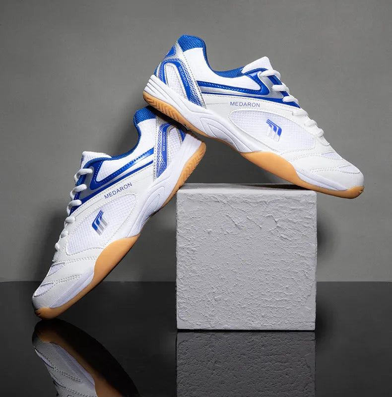 White and blue unisex table tennis training sneaker with lace-up front and rubber sole.