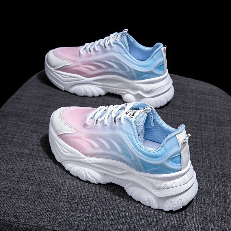 Women's blue satin casual sport shoes with round toe and white laces on a flat lay.