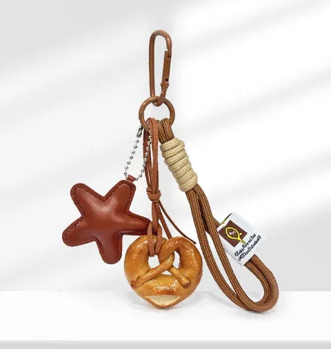 Handmade resin soda bread handbag pendant with baking varnish finish and brown carrying strap.