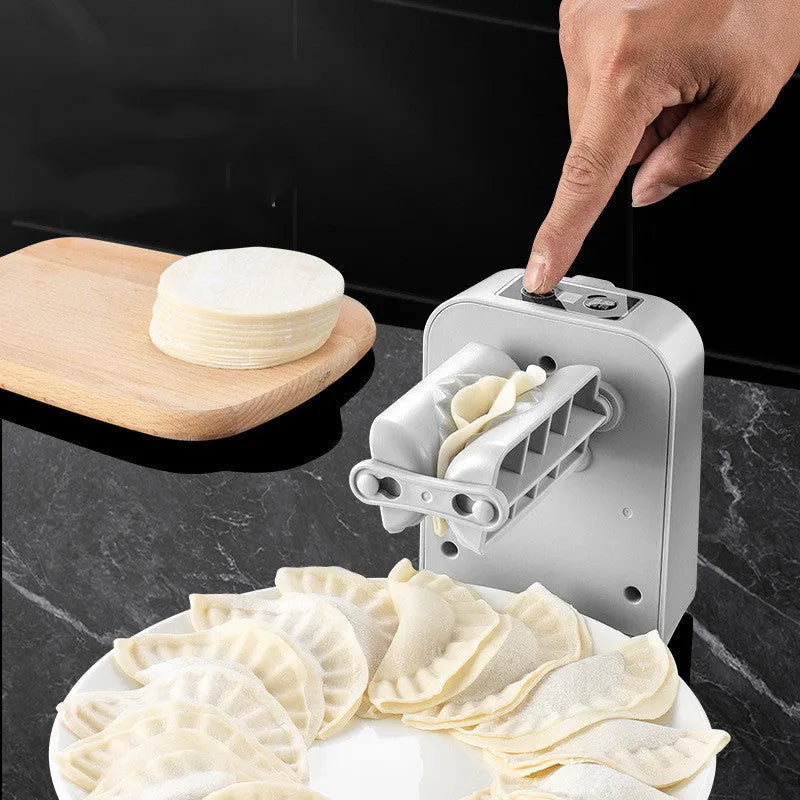 White automatic electric dumpling maker machine with charging cable, brush, and spoon.