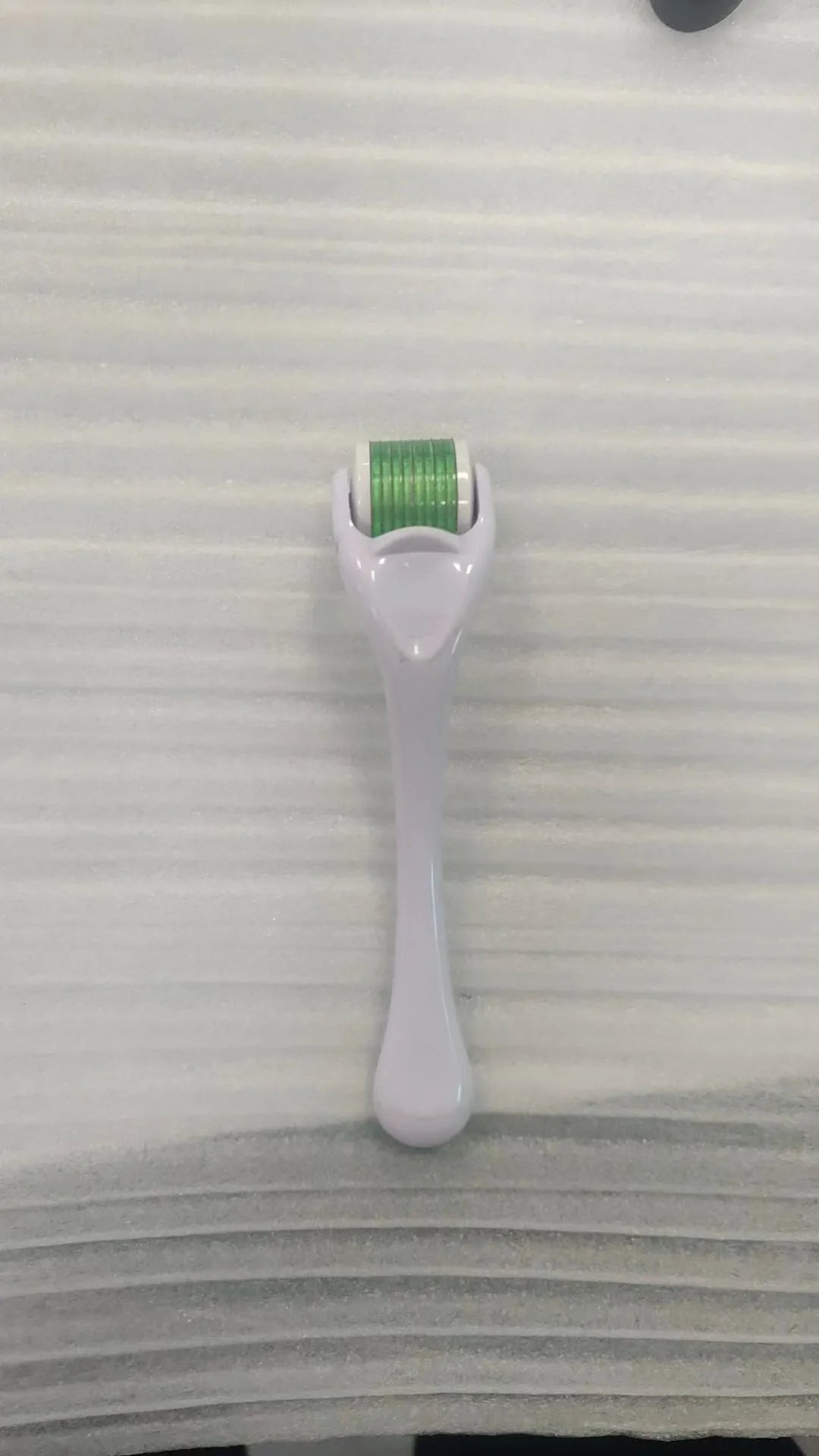 540 micro needle derma roller with black handle and purple wheel, showing adjustable needle sizes.