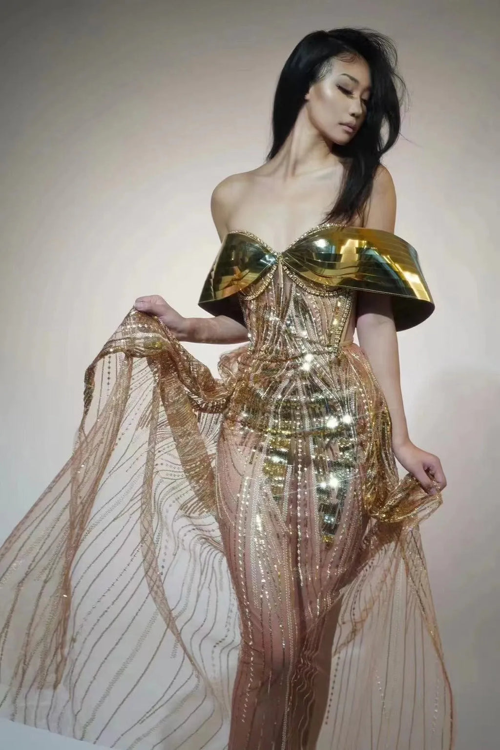 Gold metallic strapless dress with sequin details and a full tulle skirt featuring a high split.