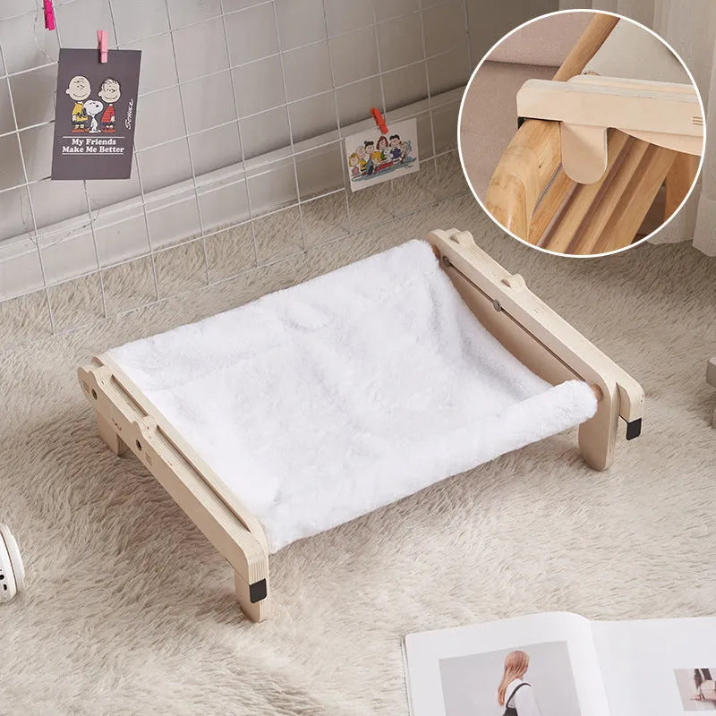 Solid wood cat bed with a removable plaid cushion on a wooden frame.