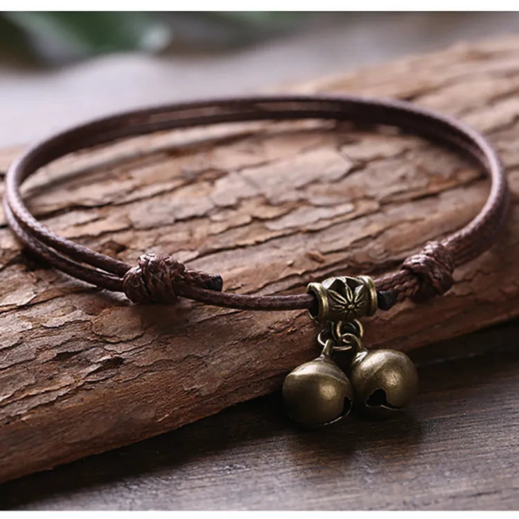 Adjustable black nylon dog collar with a brass bell for a small pet.