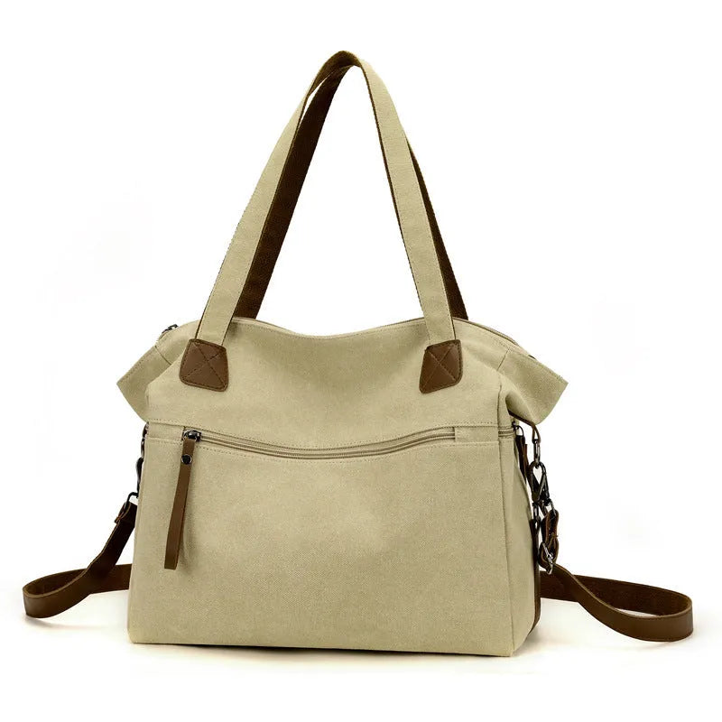 Large khaki retro canvas shoulder bag for women showing external sandwich pocket and internal organiser compartments.