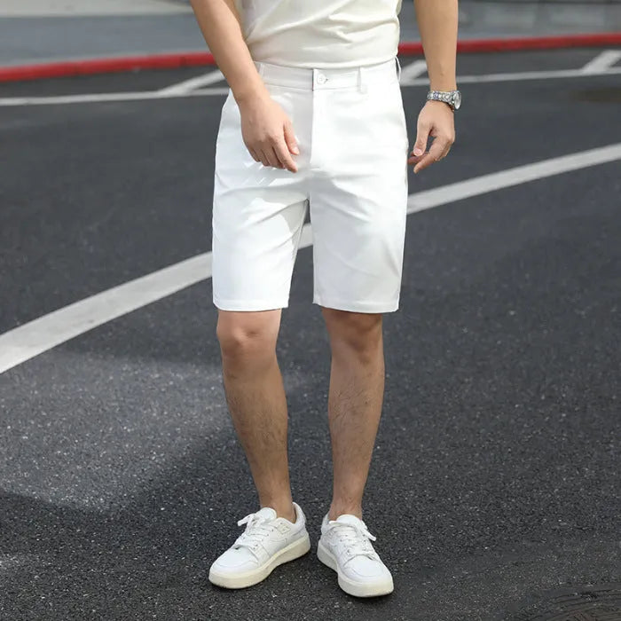 Man wearing loose-fit beige mid-length casual trousers with an elasticated waistband.