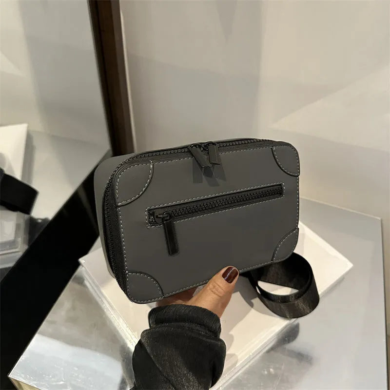 Women's black square crossbody bag showing internal mobile phone pocket and adjustable shoulder strap