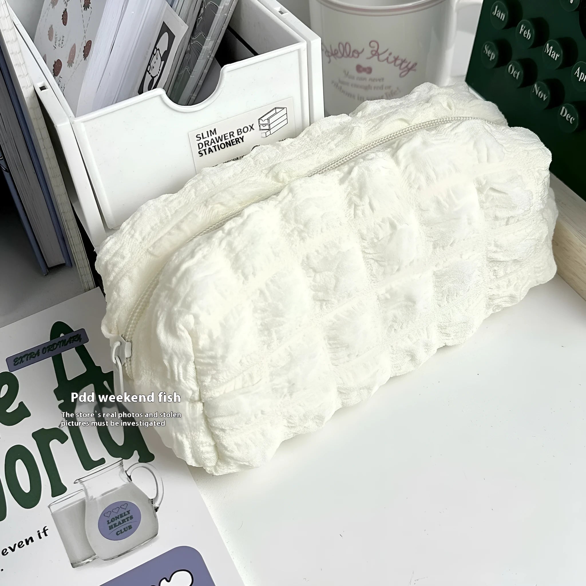 Cream puff style polyester fabric pencil case for pens, shown in beige and black colour options.