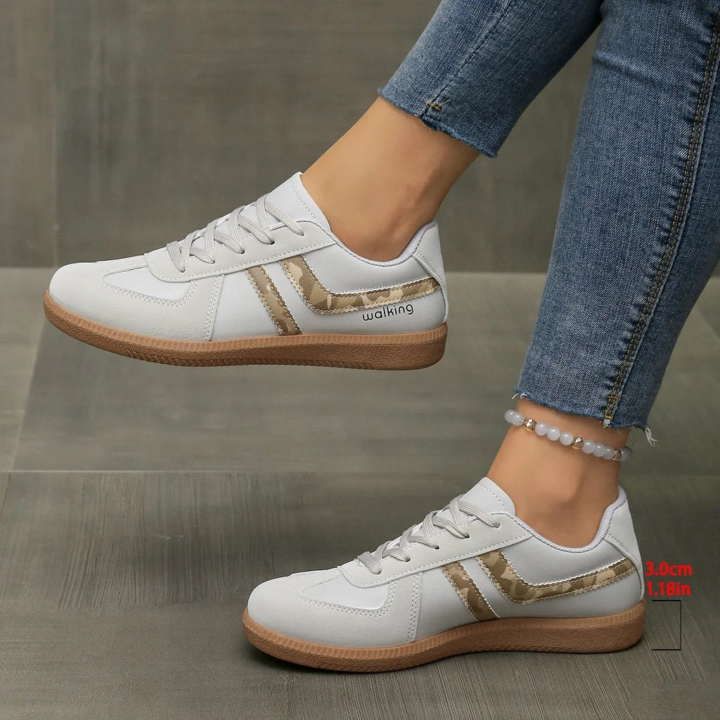 A pair of retro-style low-top lace-up sneakers in a selected colour on a plain background.