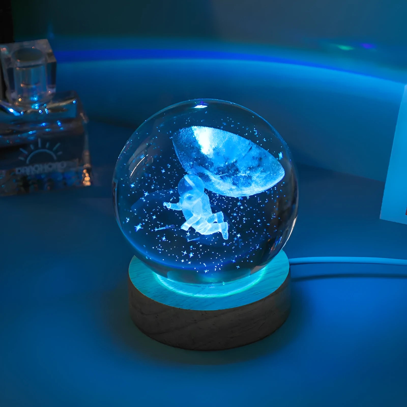 Colorful luminous crystal ball on light wooden base with data cable