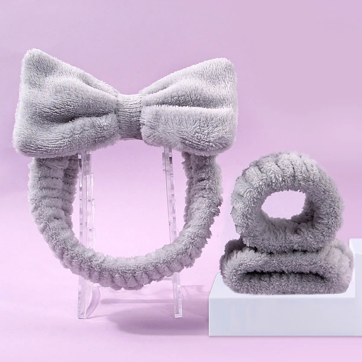 Facial brush and coral fleece hair band set in purple, grey, white, and pink colours.