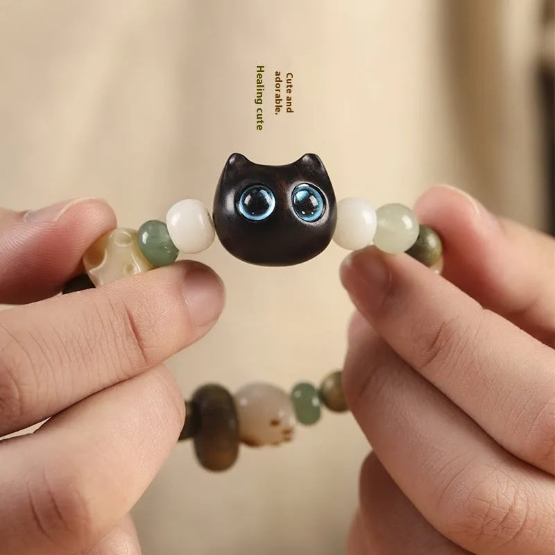 Hand-woven multi-treasure bracelet with Bodhi seeds, jade, and wood beads featuring a cat's paw charm.