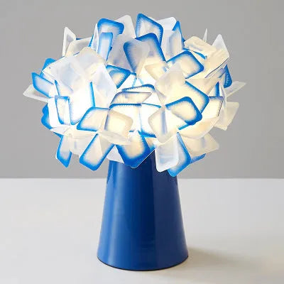 Nordic style decorative table lamp with metal base in a choice of colours on a bedside table.