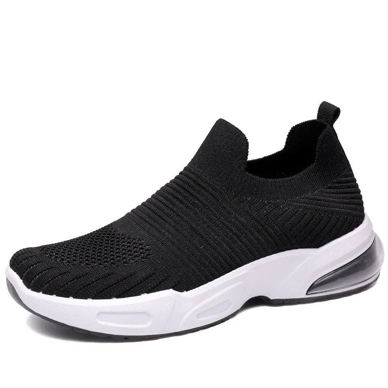 A pair of low-top slip-on sock shoes with a mesh upper and PVC sole on a plain background.