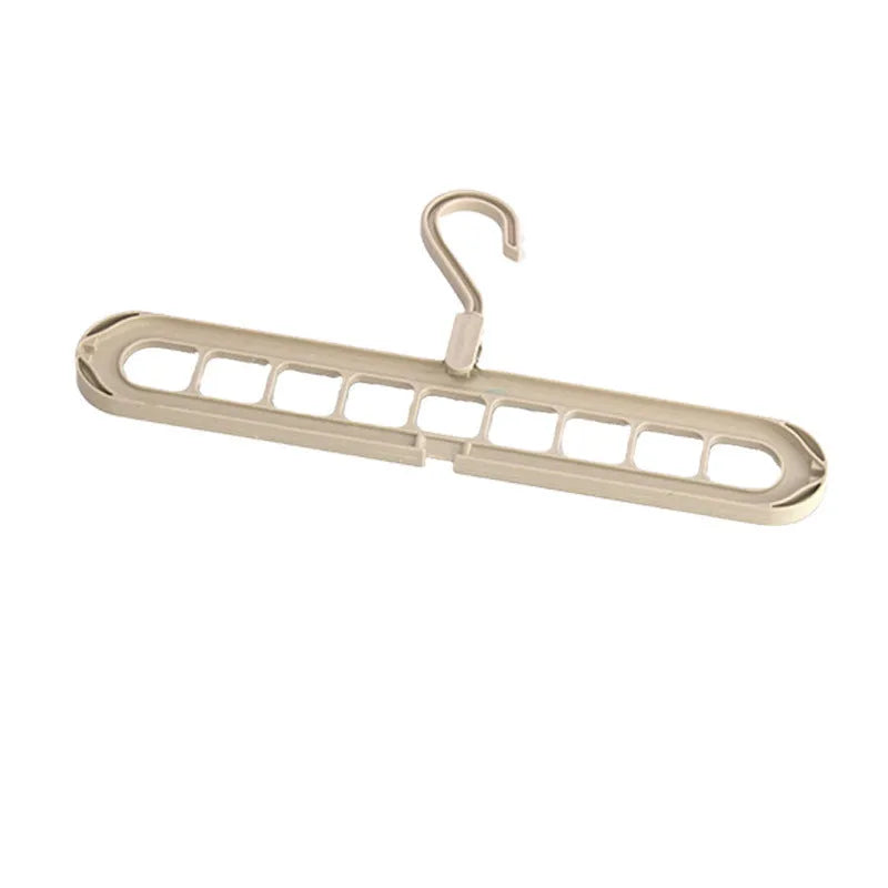 Green plastic nine-hole multifunctional clothes hanger for trousers on a white background.