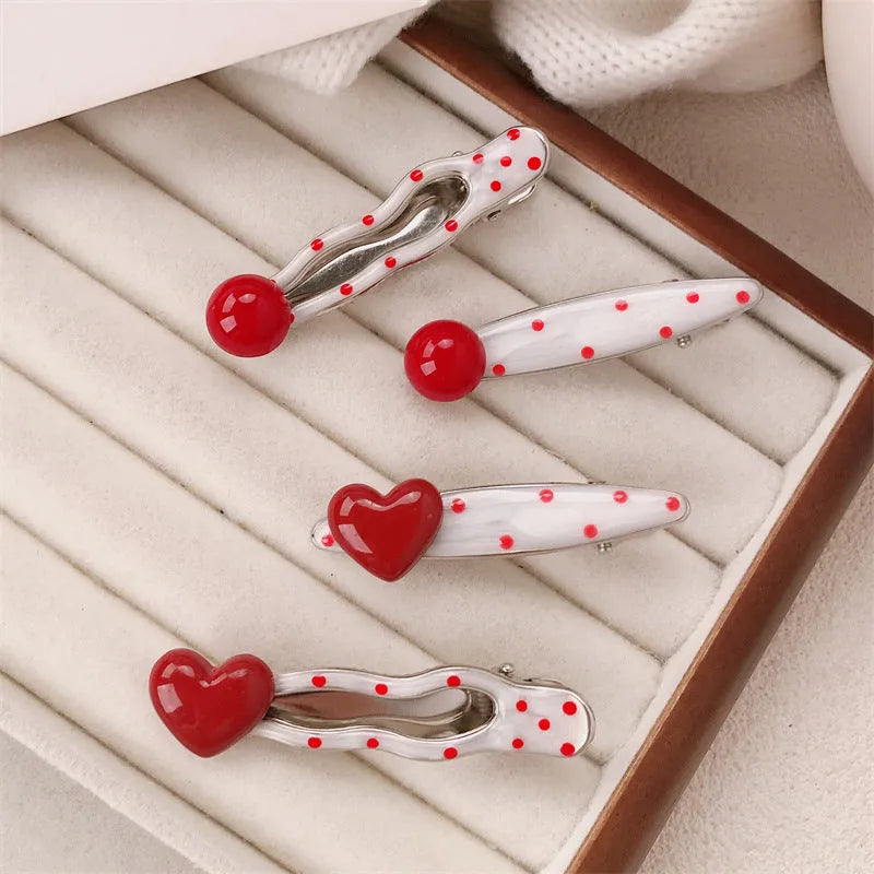 Red love heart-shaped plastic hair clip with retro dots and a willow leaf silhouette on a white background.