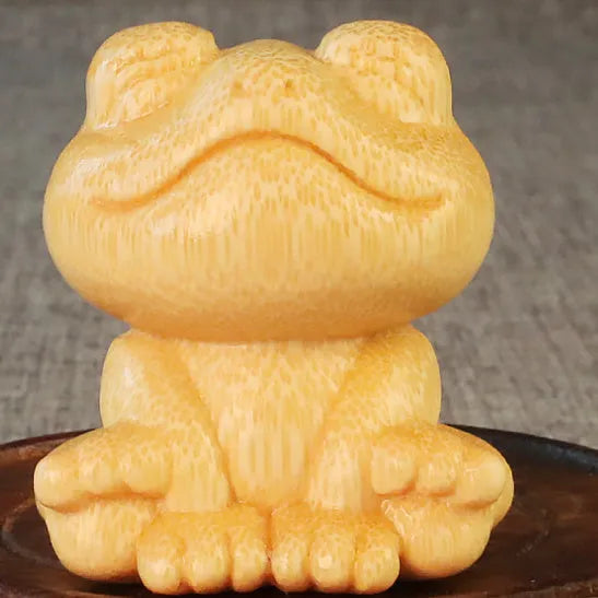 Solid bamboo carved ornament of a smiling cartoon frog, 5cm tall.