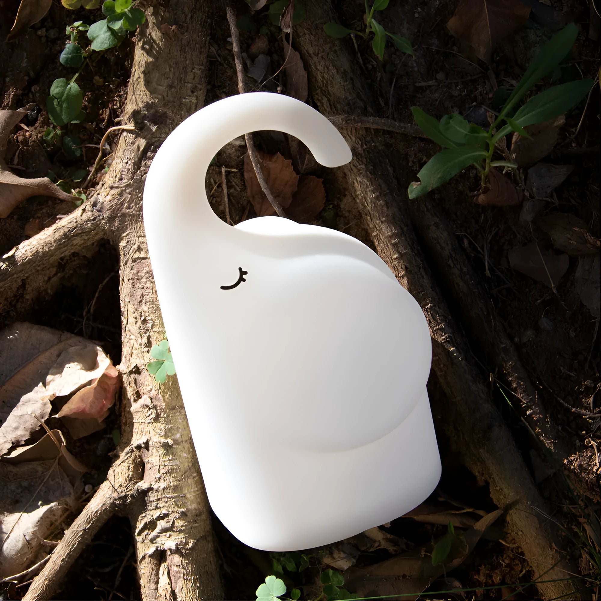 DOMI Elephant style silicone and plastic LED night light with warm white glow on a bedside table.