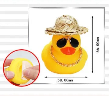Yellow duck cartoon character wearing a straw hat, a car dashboard ornament with miniature sunglasses accessory.