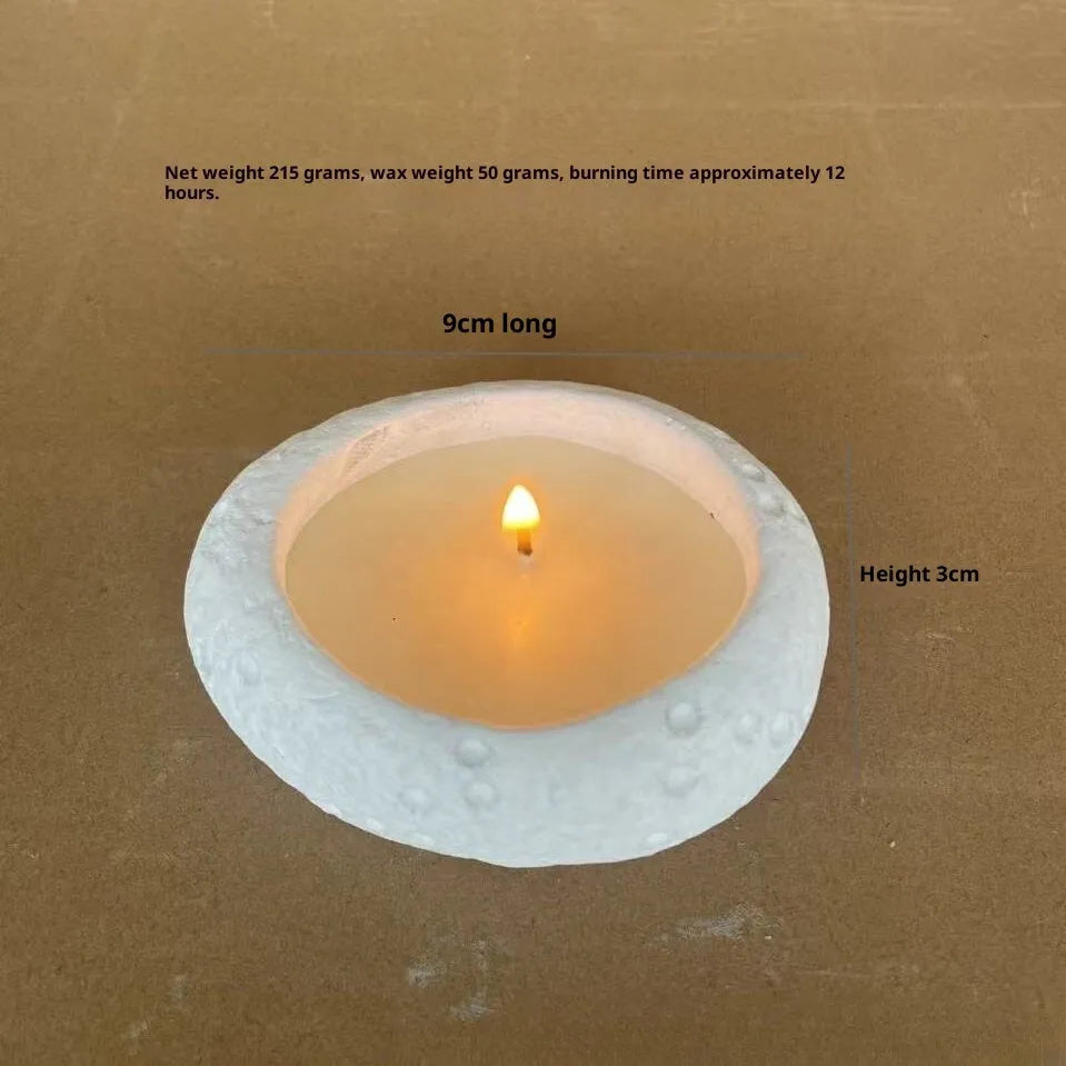 White concrete candle holder on a flat surface with a tea light inside