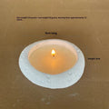 White concrete candle holder on a flat surface with a tea light inside