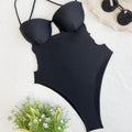 Black one-piece bikini-style swimsuit for women on a hanger.