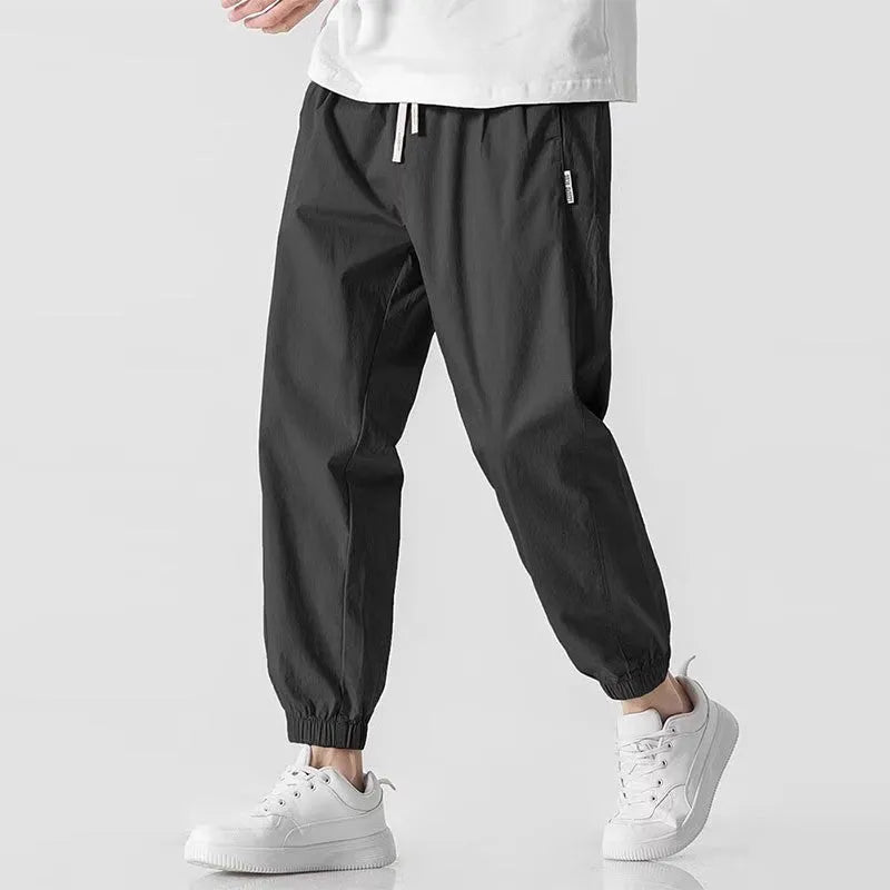 Men's loose cuffed cargo pants in black polyester fabric with cuffed hem and relaxed fit