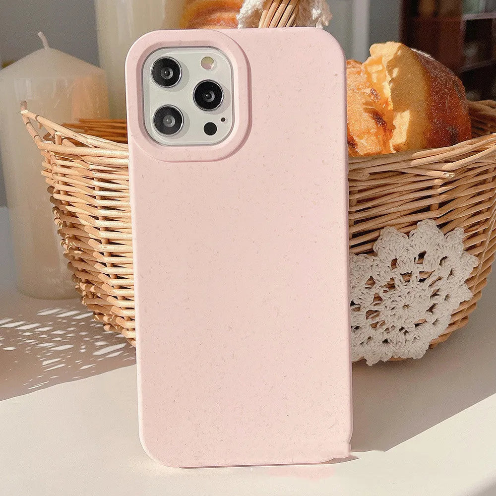 Degradable wheat straw phone case for Apple iPhone on a wooden surface.