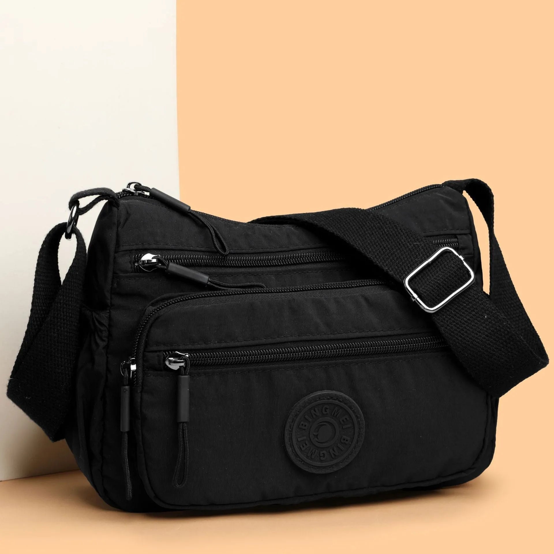 Grey water-repellent nylon crossbody bag showing outer pocket and internal organiser compartments.