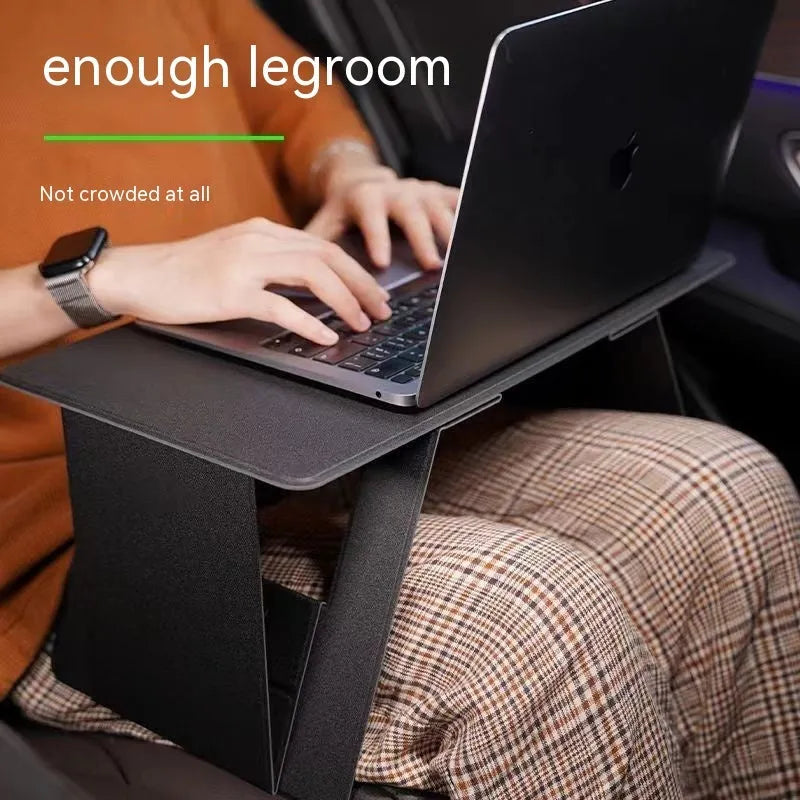 Foldable wooden laptop stand in black with storage area and folded legs on a flat surface