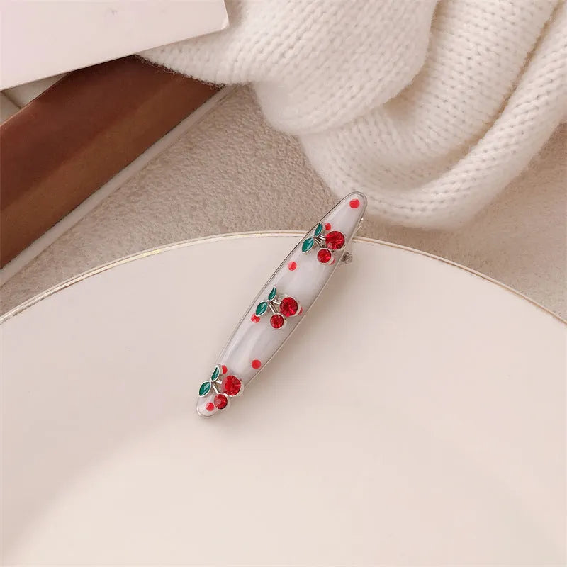 Red love heart-shaped plastic hair clip with retro dots and a willow leaf silhouette on a white background.