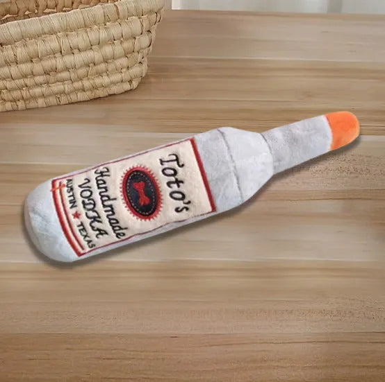 Brown plush dog toy shaped like a wine bottle with squeaker for chew play