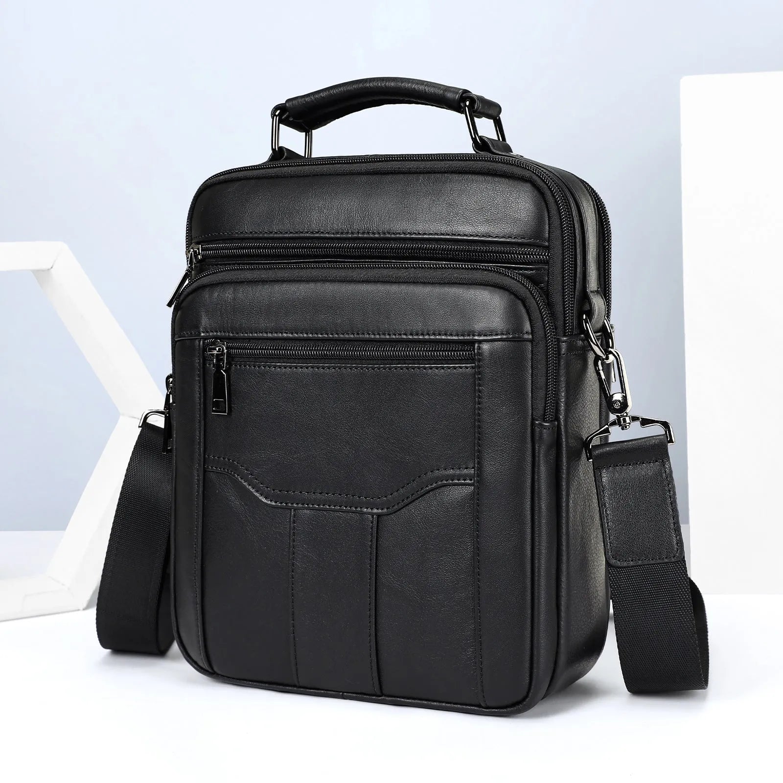 Men's genuine leather messenger bag in black with visible sewing line details and shoulder strap