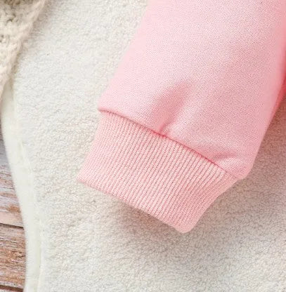 Pink two-piece girls' suit with long sleeve flounced sleeve knitted sweater, printed bow, and flared pants on white background