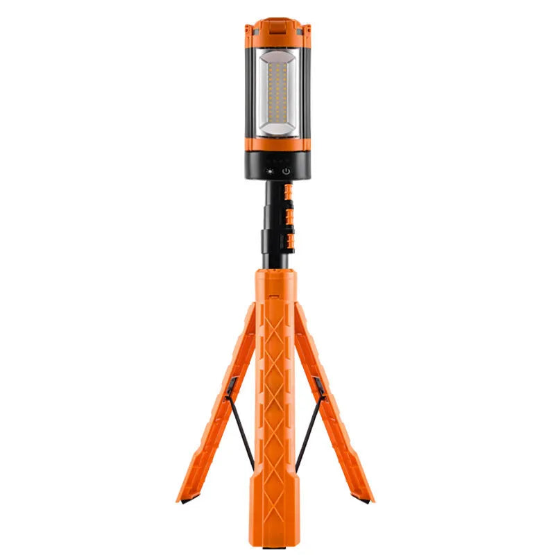 Retractable folding charging camping lantern in black and orange with bracket and pull string extended on a table
