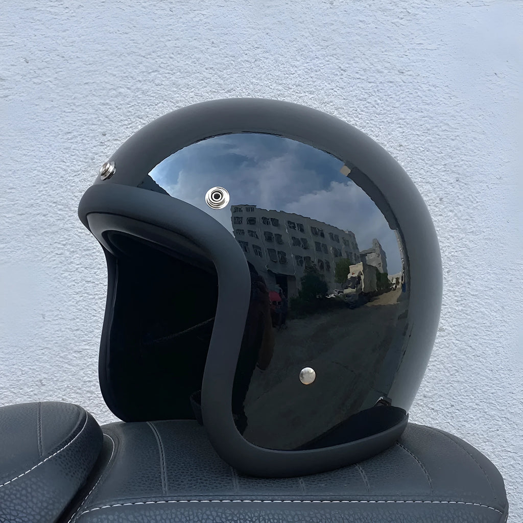 A retro-style grey half helmet for motorcycle riding, shown on a stand.