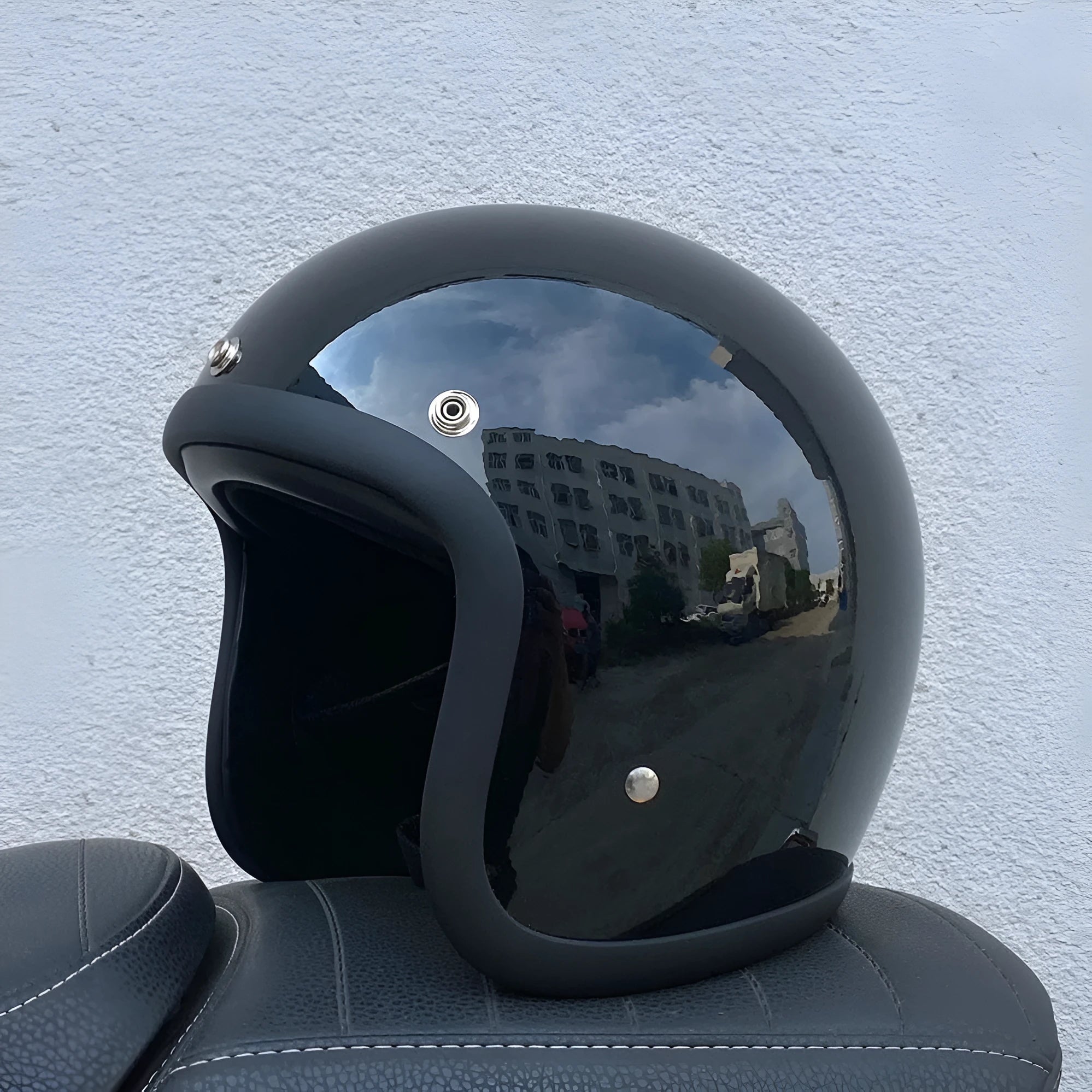 A retro-style grey half helmet for motorcycle riding, shown on a stand.