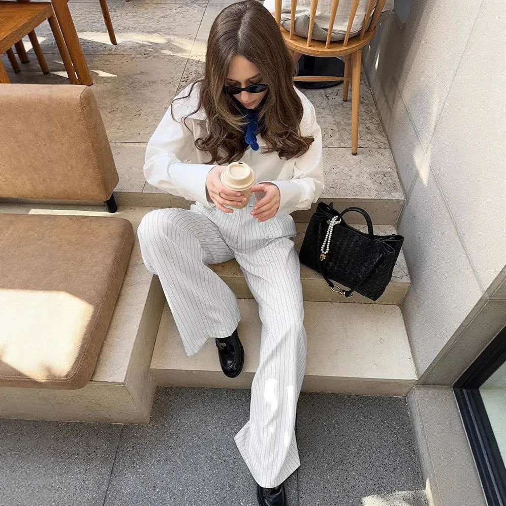 White striped wide-leg casual trousers with a zipper fastening on a neutral background.