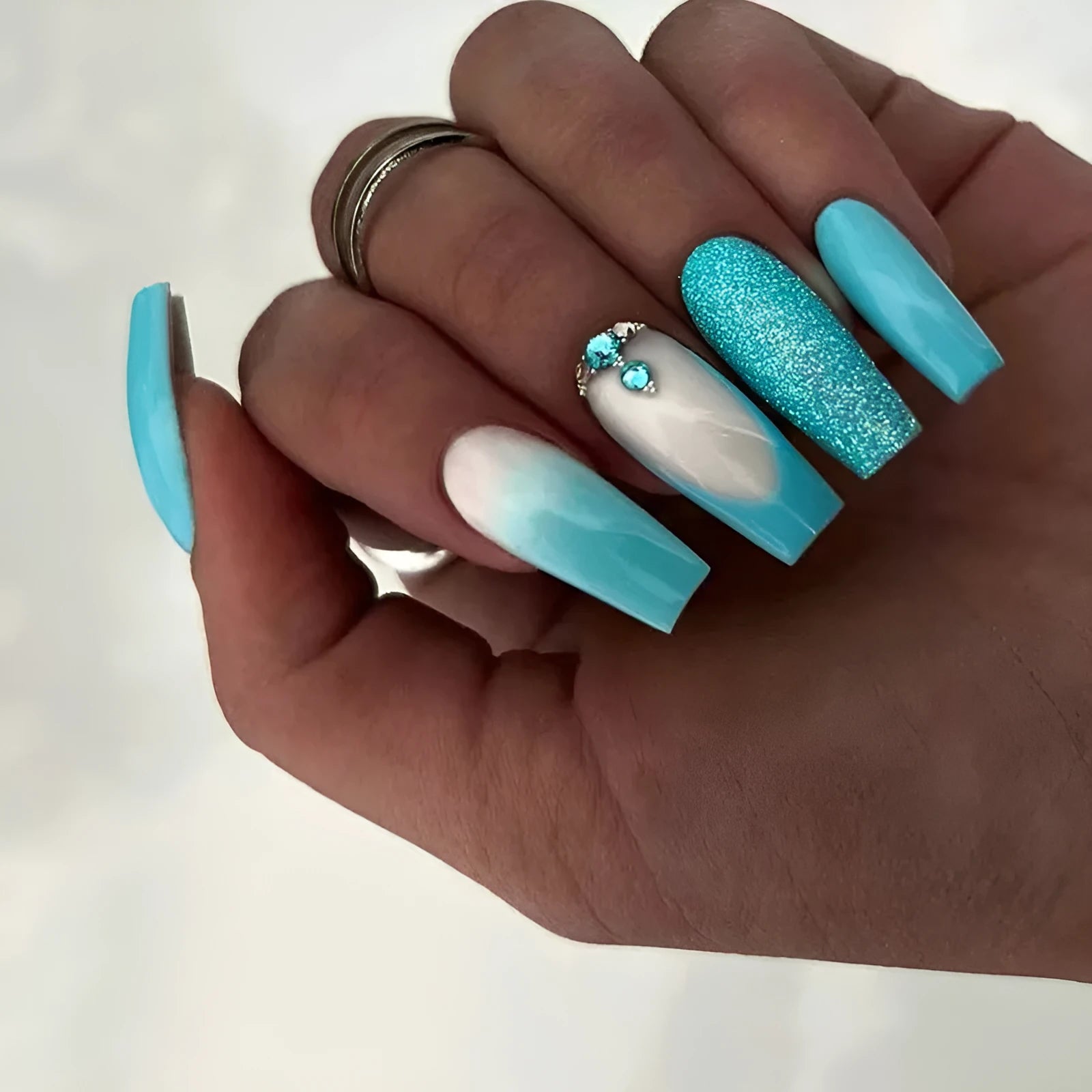 Solid blue long ballet false nails with diamond glitter design and included adhesive glue.