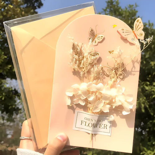 Handmade 3D butterfly-shaped greeting card with artificial flowers in a box, alongside its matching envelope.