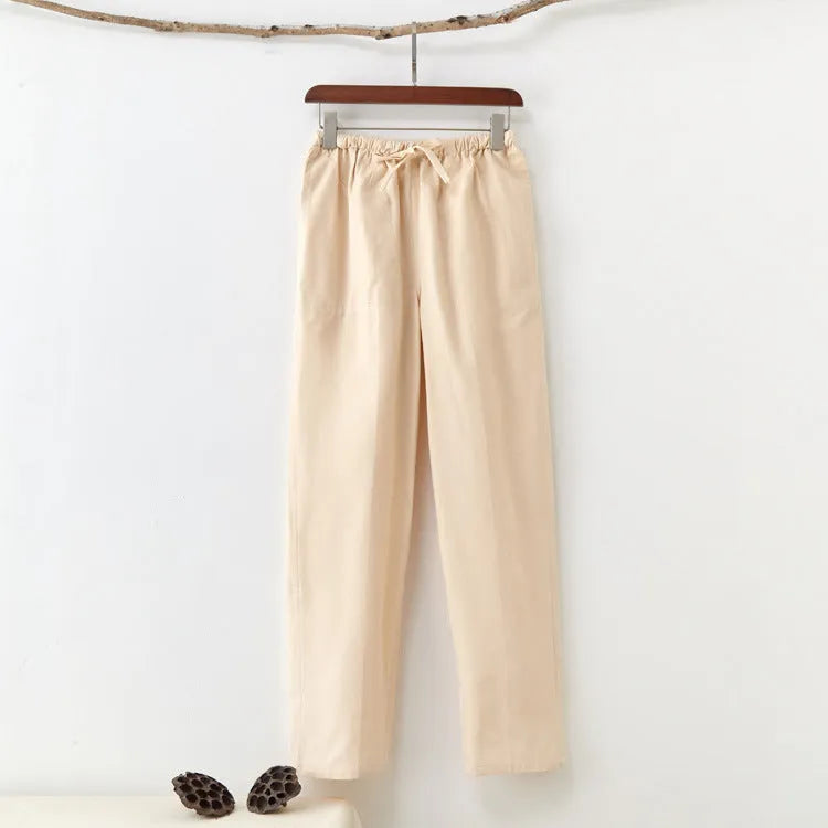 Man wearing beige pure cotton casual trousers with a drawstring waist and belt.