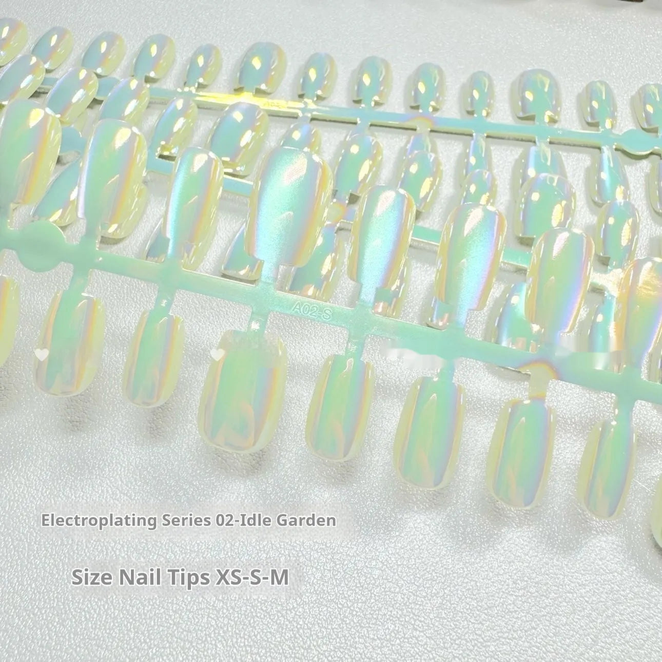 Set of electroplated Cat's Eye false nails in short ladder lengths on a clear stand.